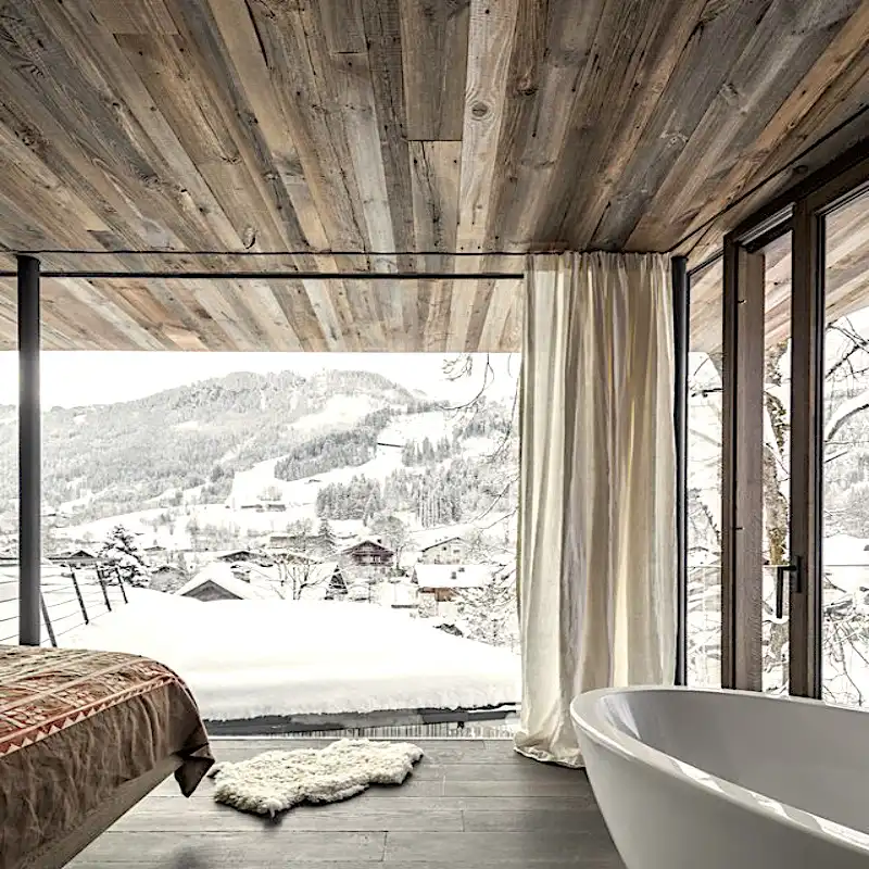  Une chambre avec un plafond en bois rustique et baignoire avec vue sur une montagne enneigée 