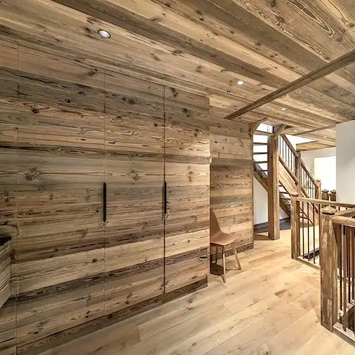  Une pièce avec des murs en lambris bois vieilli et un escalier 