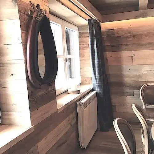  Une salle à manger avec des murs en bois et une table en bois recyclé 