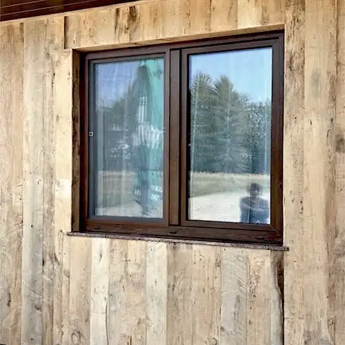  Une fenêtre en vieux bois dans une maison avec une personne à l’intérieur. 
