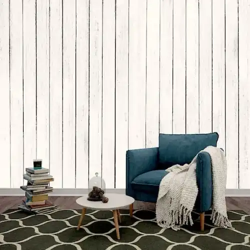  Un salon avec un mur en lambris bois blanc vieilli et une chaise bleue.  