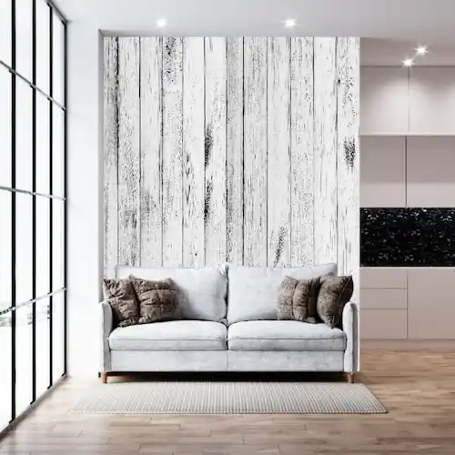  Un salon avec un mur en lambris bois blanc vieilli. 
