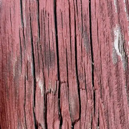  Un gros plan d'une clôture en vieux bois peinte en rouge. 