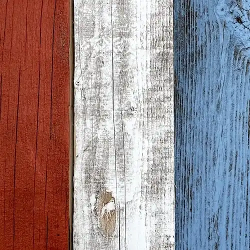 Un gros plan d'une clôture en vieux bois rouge, bleue et blanche. 