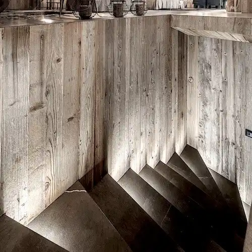  Un escalier en bois menant à un bar gris 