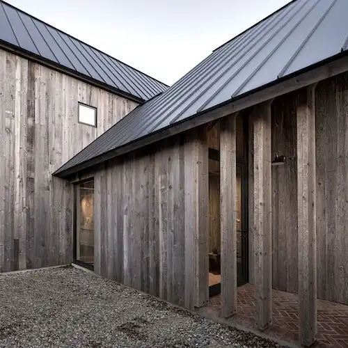  Une maison en bardage bois gris avec un toit en métal 