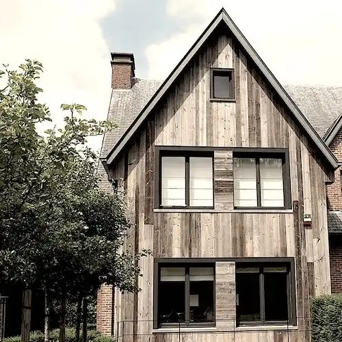 Une maison avec bardage bois gris et beaucoup de fenêtres 