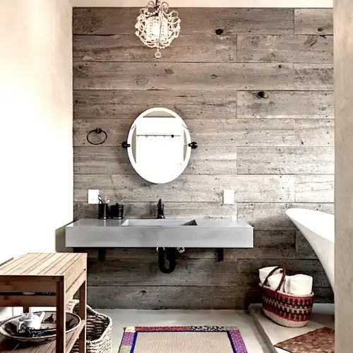  Une salle de bain avec murs en bois recyclé et baignoire en bois. 