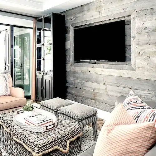  Un salon avec une télé sur un mur en bardage gris 