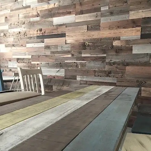  Un mur en bois ancien avec une table et des chaises en bois 