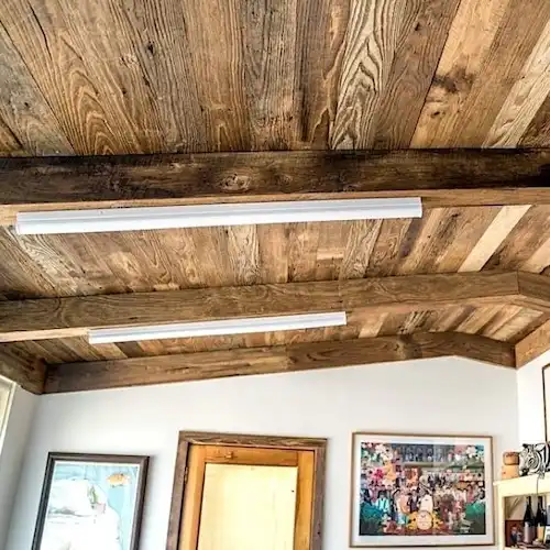  Le plafond d'une pièce est constitué de poutres en bois. 