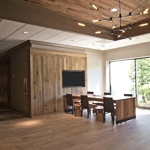  Un plafond en bois avec bardage châtaignier dans une pièce avec une table et des chaises. 