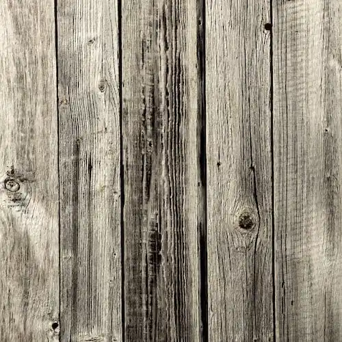 Une image en gros plan d'une clôture en bois avec bardage bois gris (bardage en bois).