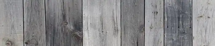 un gros plan d'une clôture en bardage bois gris avec un fond blanc