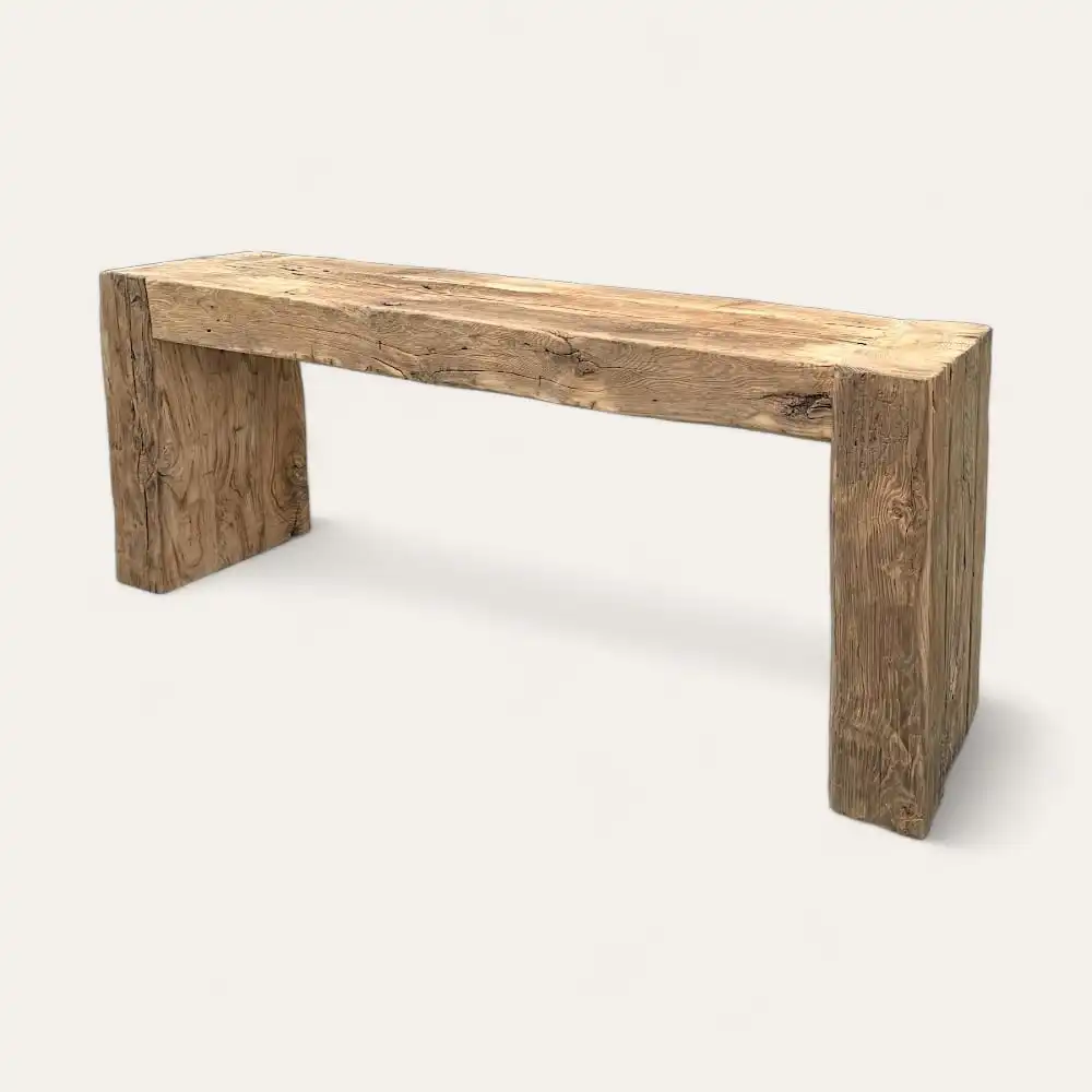  Un banc en bois composé de planches épaisses et rustiques au design simpliste rappelant une console en bois ancien. 