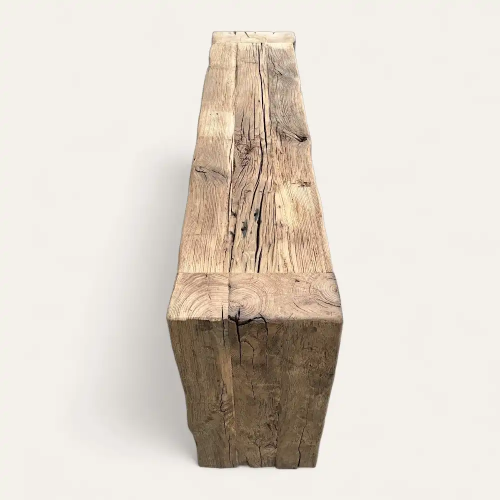  Un meuble rectangulaire en bois, peut-être une console en bois ancien, fabriqué à partir d'une seule bûche patinée avec des fissures et des textures naturelles visibles. Le fond est uni et blanc. 