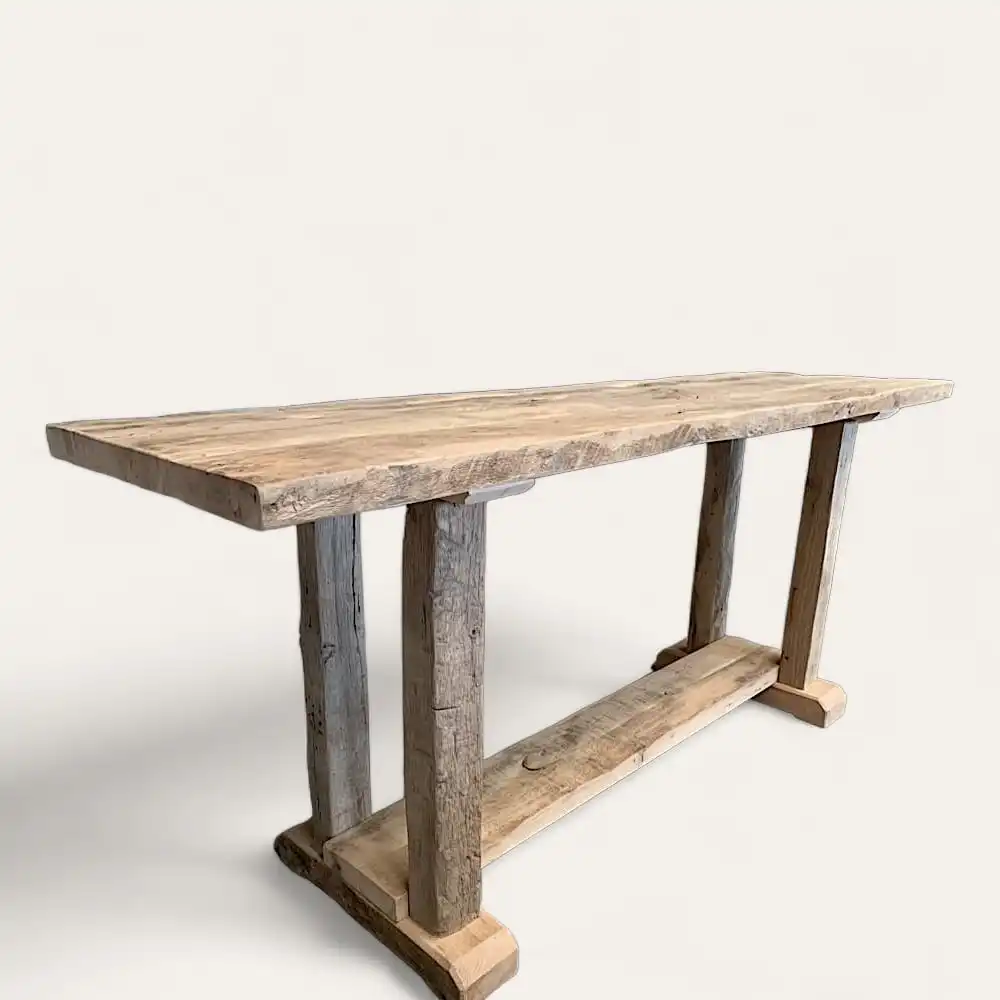  Image d'une table console rustique en bois ancien avec un plateau rectangulaire et des pieds robustes, positionnée sur un fond blanc uni. 