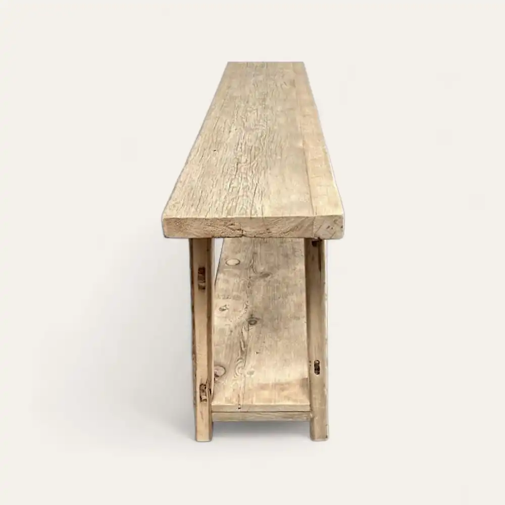  Un banc en bois avec un siège rectangulaire étroit et un grain de bois visible, doté d'une tablette de support inférieure, ajoute une touche de charme rustique à n'importe quel décor. 