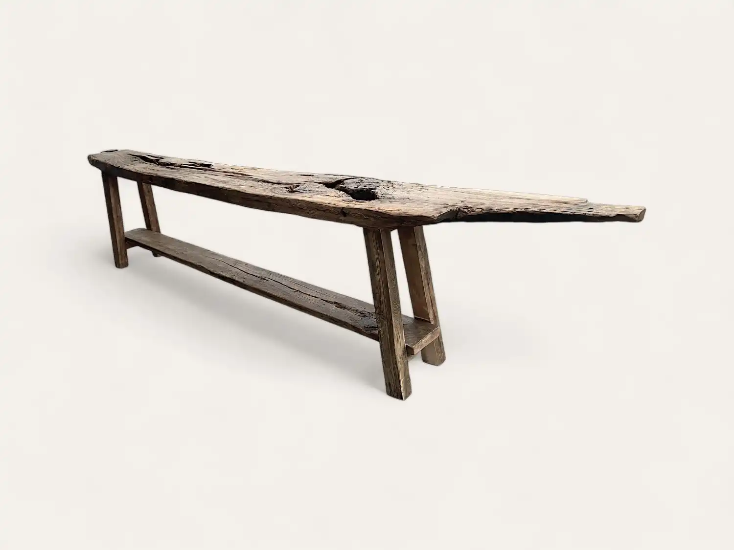 Un pied de table en bois ancien avec une base à trois pieds sur fond blanc.