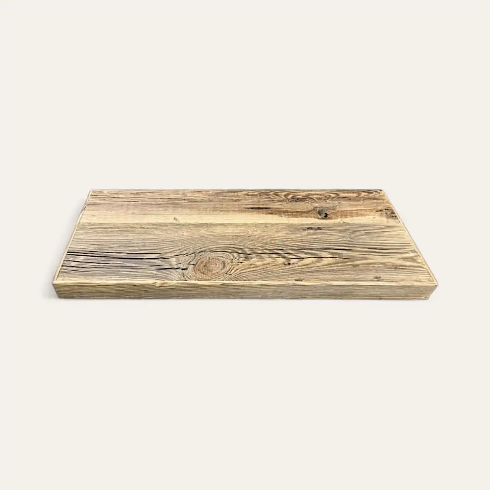  Une planche à découper rectangulaire en bois avec des motifs de grains et de nœuds apparents, évoquant le charme du bois ancien brun, sur un fond blanc uni. 