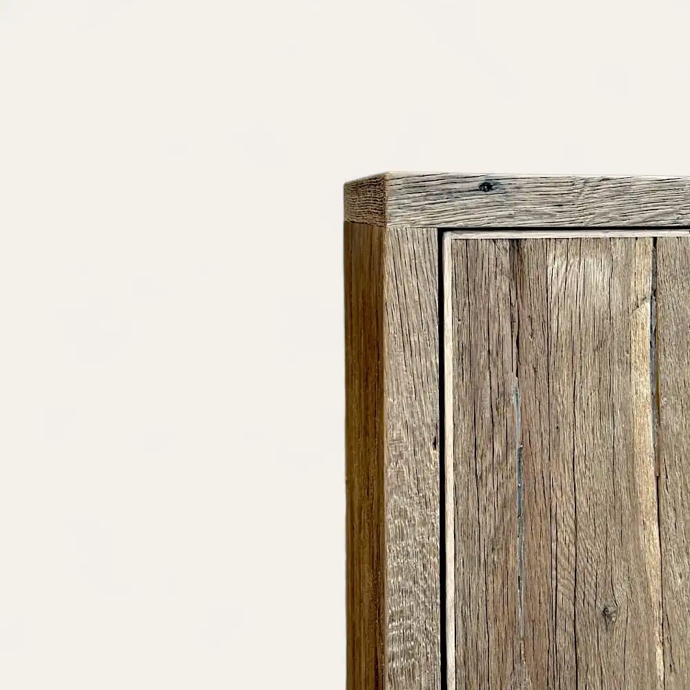  Une table en bois longue et étroite avec une finition claire et naturelle. La table a des pieds carrés et un design minimaliste, rappelant un meuble en bois ancien, présenté sous une vue latérale inclinée. 