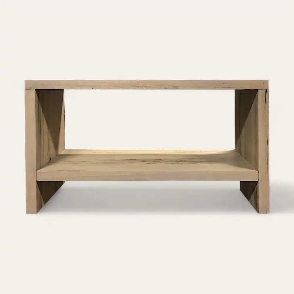  Une table basse simple et rectangulaire en bois avec une étagère ouverte sous le plateau, rappelant un meuble en bois ancien, sur un fond uni. 