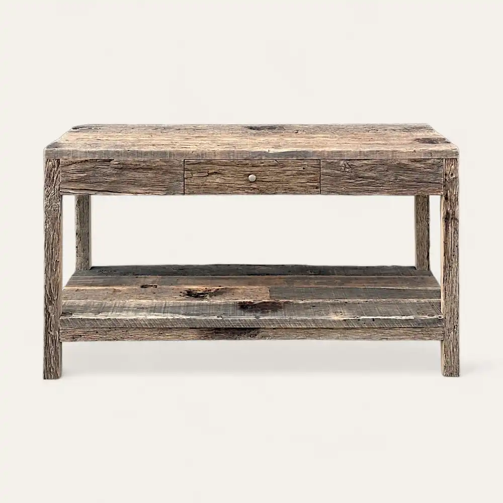  Une console rustique en bois avec un seul tiroir central et une étagère inférieure, incarnant le charme intemporel du meuble en bois ancien, sur un fond uni blanc cassé. 