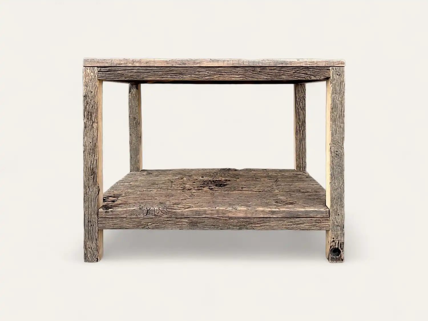 Une table d'appoint rustique en meuble bois ancien avec une étagère inférieure, présentant une texture naturelle patinée et une construction robuste sur un fond uni.