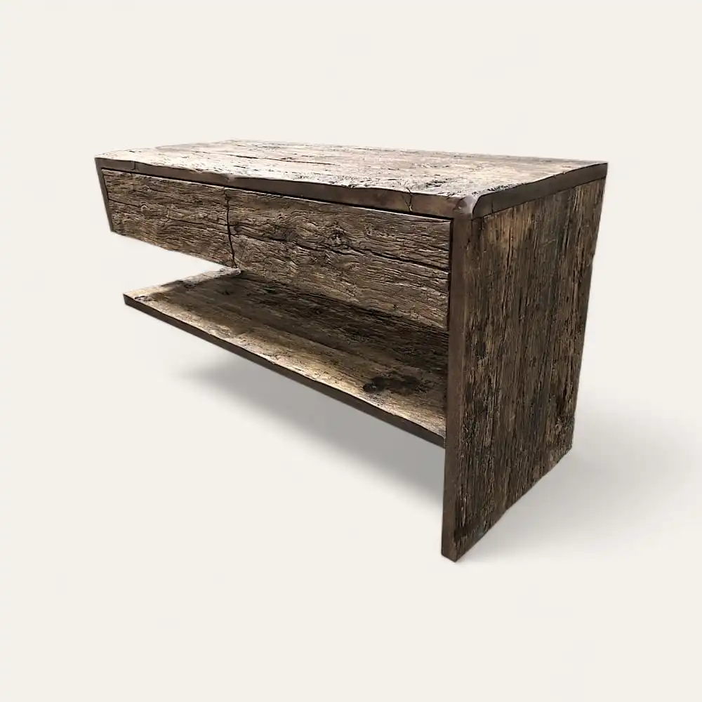  Une console rustique en bois avec un plateau rectangulaire, un seul tiroir et une étagère inférieure ouverte, en bois vieilli et patiné, idéale comme meuble de salle de bain en bois ancien. 