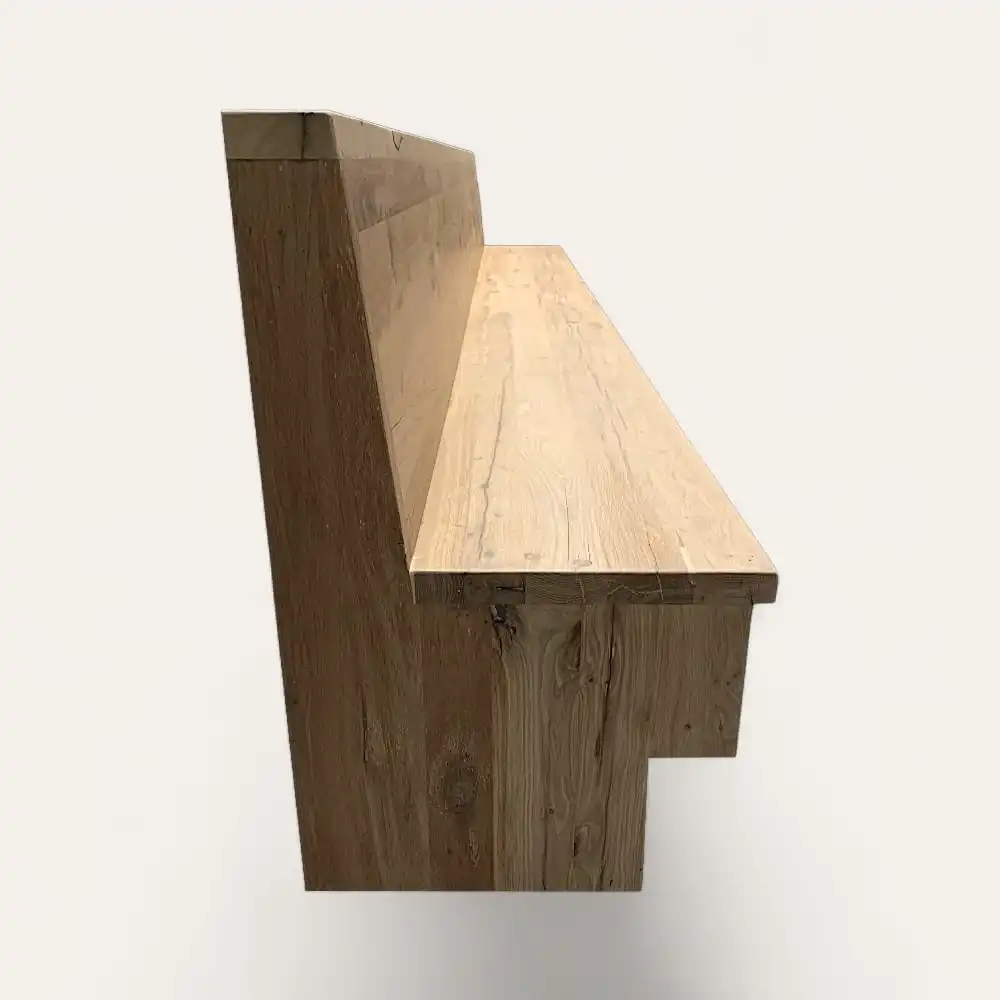  Vue latérale d’un banc en bois au design simple et rustique. Le banc comporte un dossier droit et une assise plate. Le banc bois ancien a une finition naturelle et des motifs de grains visibles. 