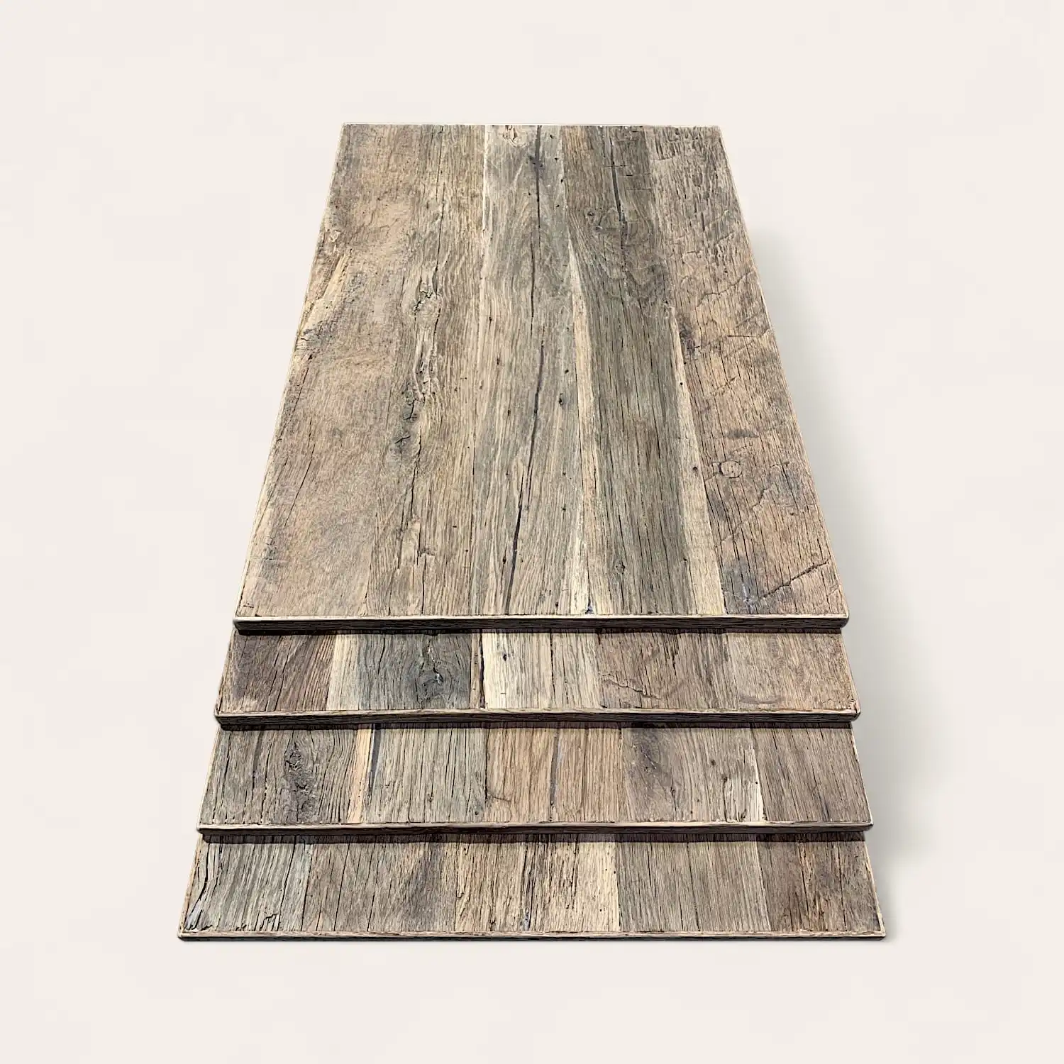  Pile de quatre planches de bois patinées avec des surfaces texturées, disposées de manière superposée sur un fond clair. 