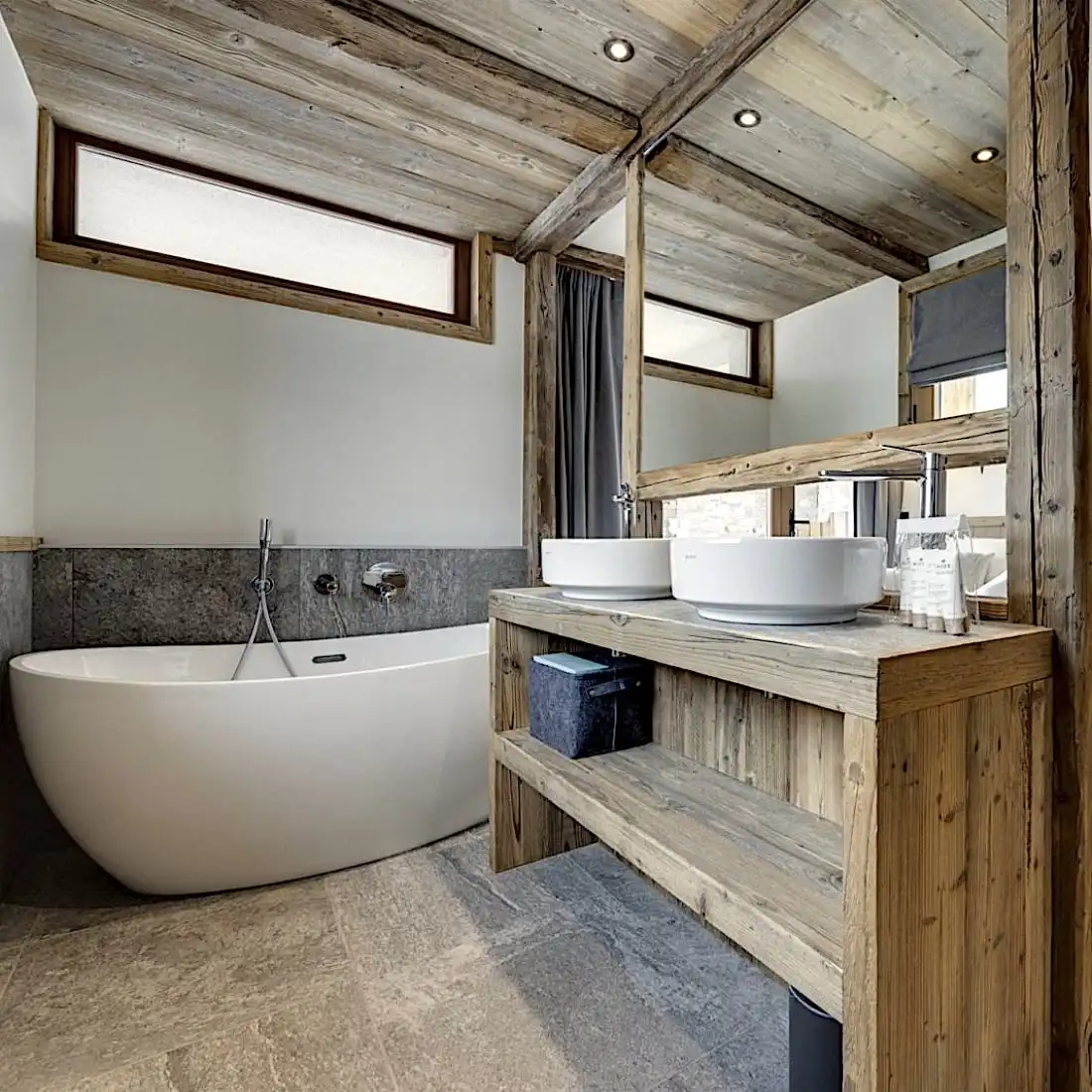  Une salle de bain moderne avec des accents rustiques en panneaux de vieux bois, une baignoire autoportante et des lavabos doubles au décor minimaliste. 
