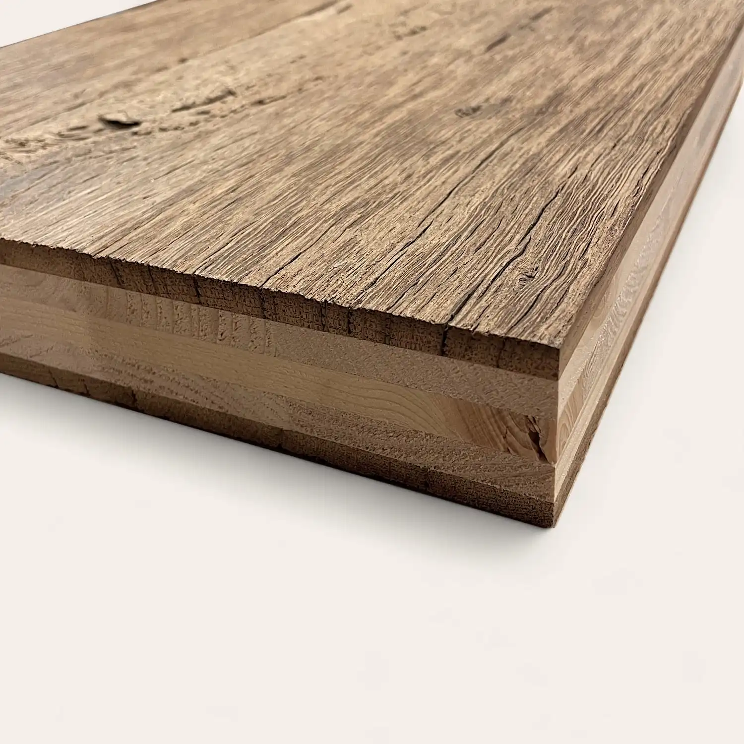  Gros plan d'une planche de bois texturée montrant le grain et les bords détaillés du bois, placée sur une surface blanche. Ceci est un exemple de panneaux vieux bois. 