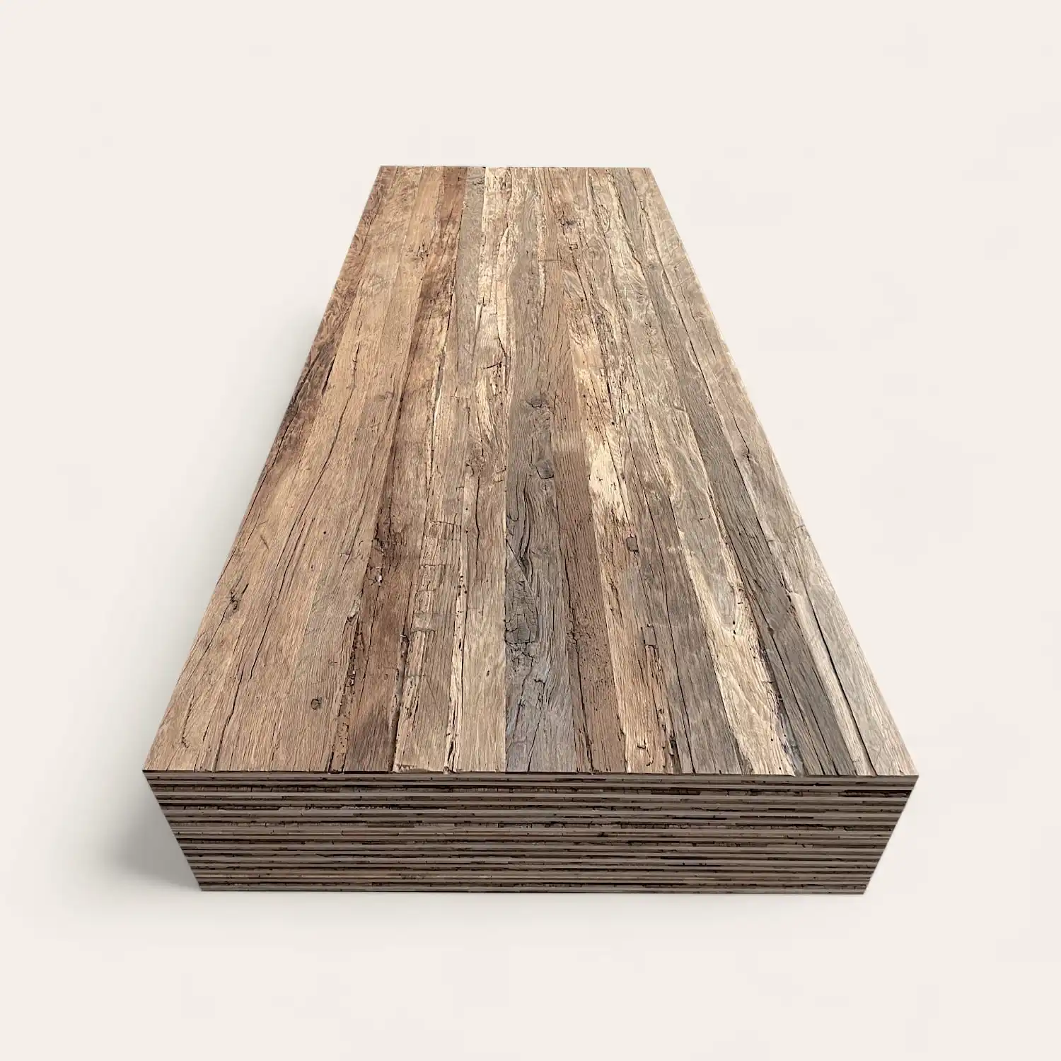  Une pile de planches de bois patinées disposées en une pile soignée, vue sous un angle diagonal sur un fond blanc. 