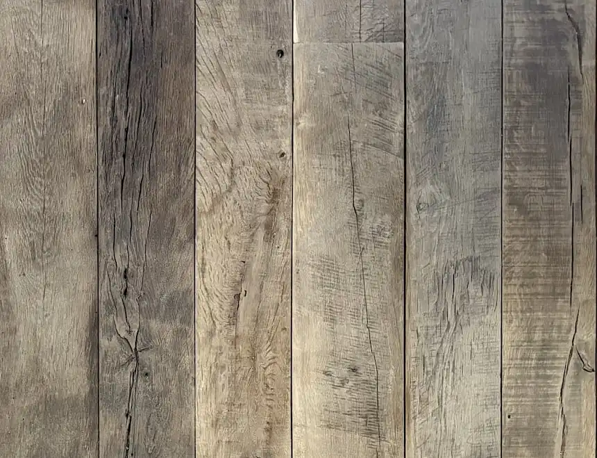 Des planches de bois verticales aux nuances et textures variées forment un fond de panneaux de bois anciens et rustiques.