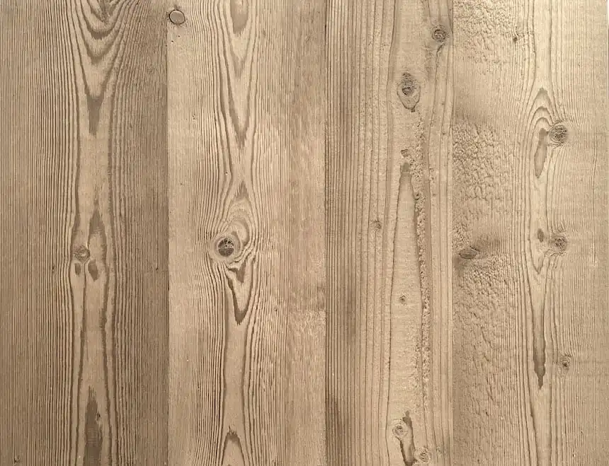 Vue rapprochée d'une surface en bois texturée avec des motifs de grains naturels et des nœuds en sapin rustique.