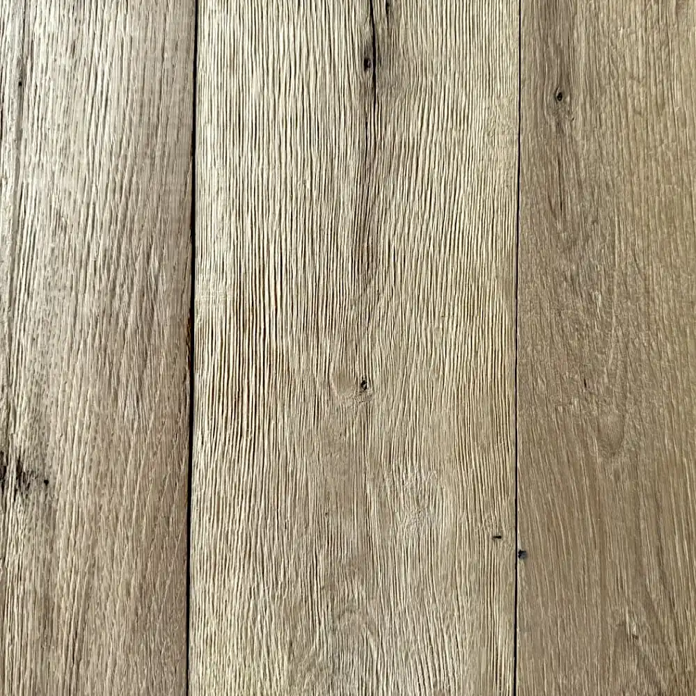  Image en gros plan de trois planches de bois avec grain, texture et quelques petits nœuds visibles. Le bois paraît vieilli avec un aspect naturel et rustique rappelant le parquet ancien. 