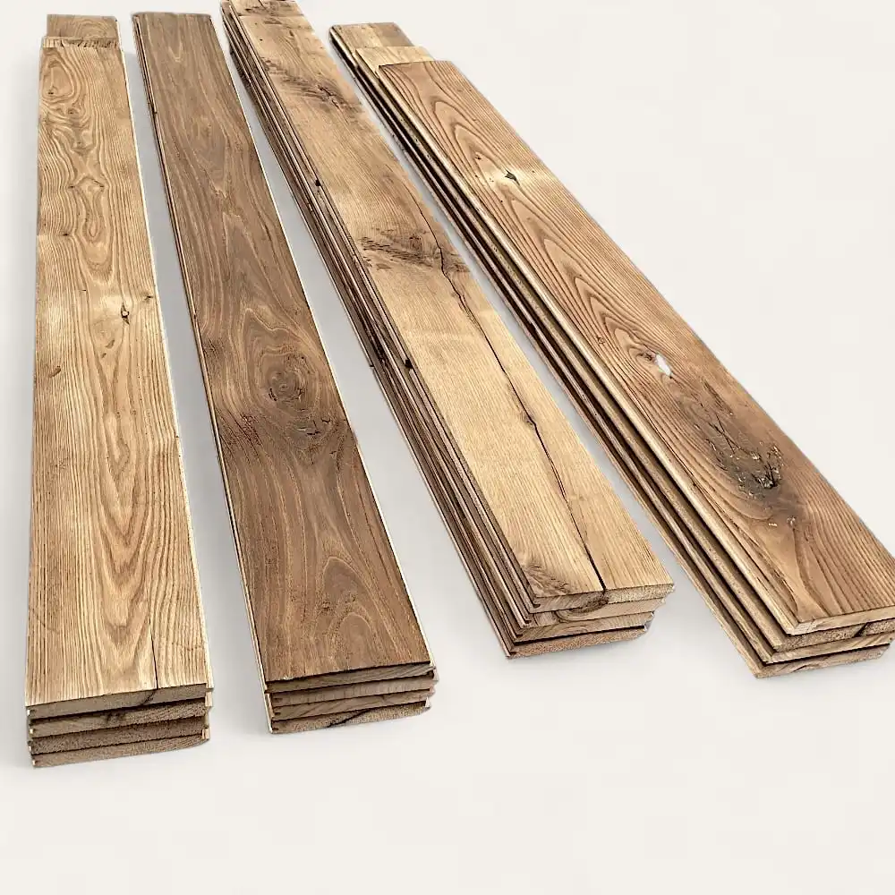  Plusieurs piles de planches de bois, dont de superbes planchers anciens châtaignier, sont disposées en rangées soignées sur un fond blanc uni. 