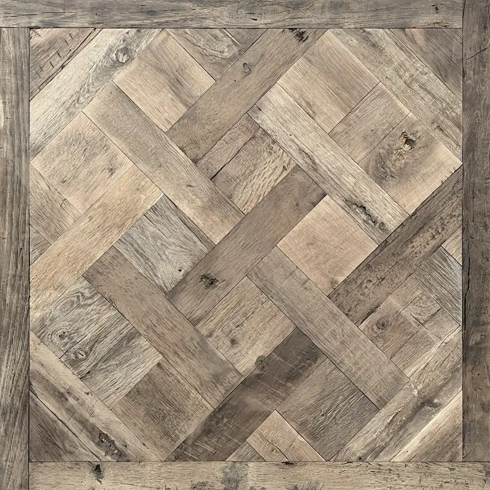  Parquet carré en bois au motif géométrique complexe composé de planches de bois clair et foncé imbriquées, encadré par une bordure de larges planches, rappelant le parquet à panneaux classique de style ancien Versailles. 