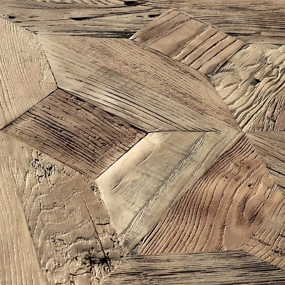  Un gros plan d'un motif géométrique en bois, rappelant le parquet étoile, composé de différentes nuances et grains de bois, mettant en valeur les textures et les dessins de joints complexes. 