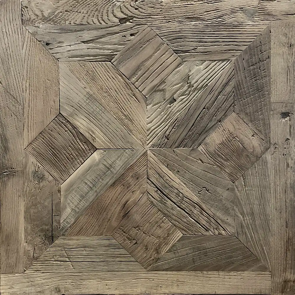  Panneau carré en bois avec un motif géométrique comprenant différentes nuances et textures de bois, formant un motif central en étoile rappelant le parquet étoile traditionnel. 