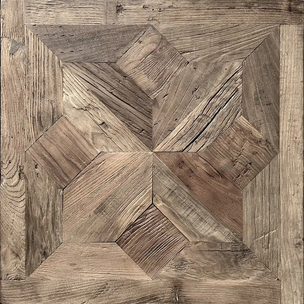  Parquet en bois à motif géométrique avec différentes nuances de brun et texture de grain de bois visible, ressemblant à un motif étoile rappelant le bois ancien. 