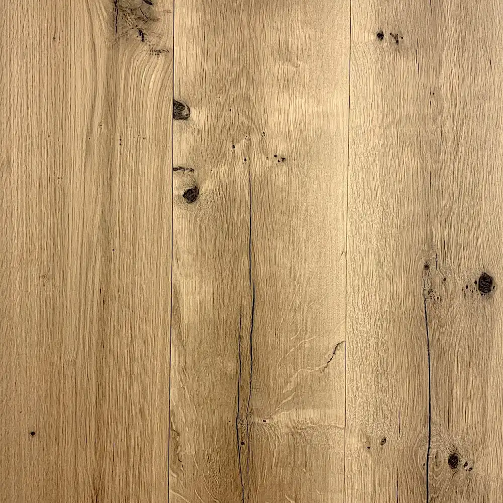  Une image en gros plan de planches de parquet vieilli marron clair présentant des motifs de grain naturel et quelques petits nœuds. 