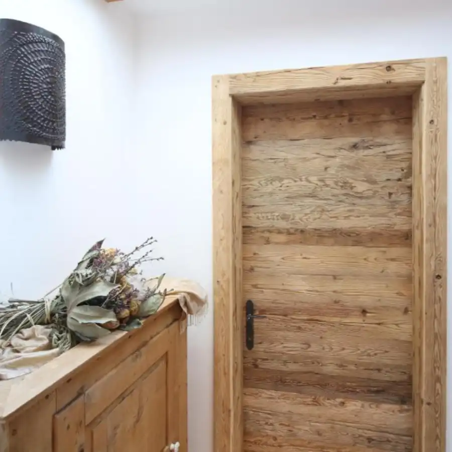  Une porte rustique en bois dans une pièce aux murs blancs. 