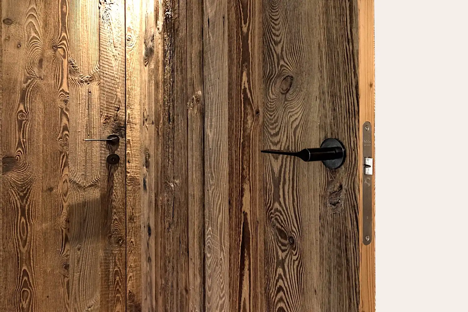 Un gros plan d'une porte de grange en bois dans une pièce.