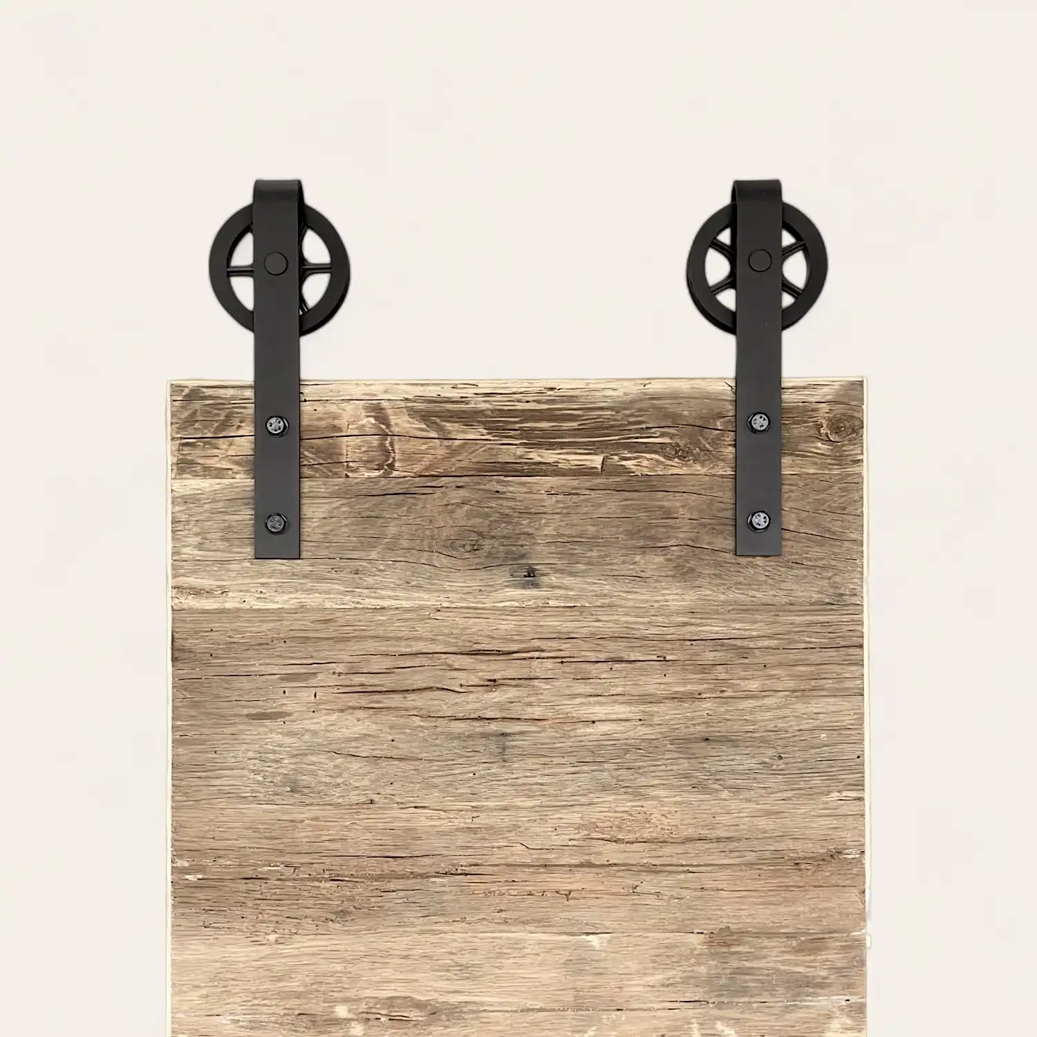  Une planche en bois rustique avec deux poignées en métal noir fixées en haut sur un fond neutre. 