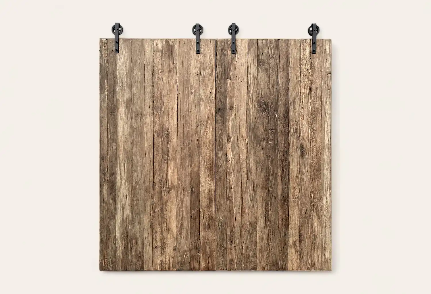 Une planche de bois patinée fixée à un mur par trois pinces métalliques noires.