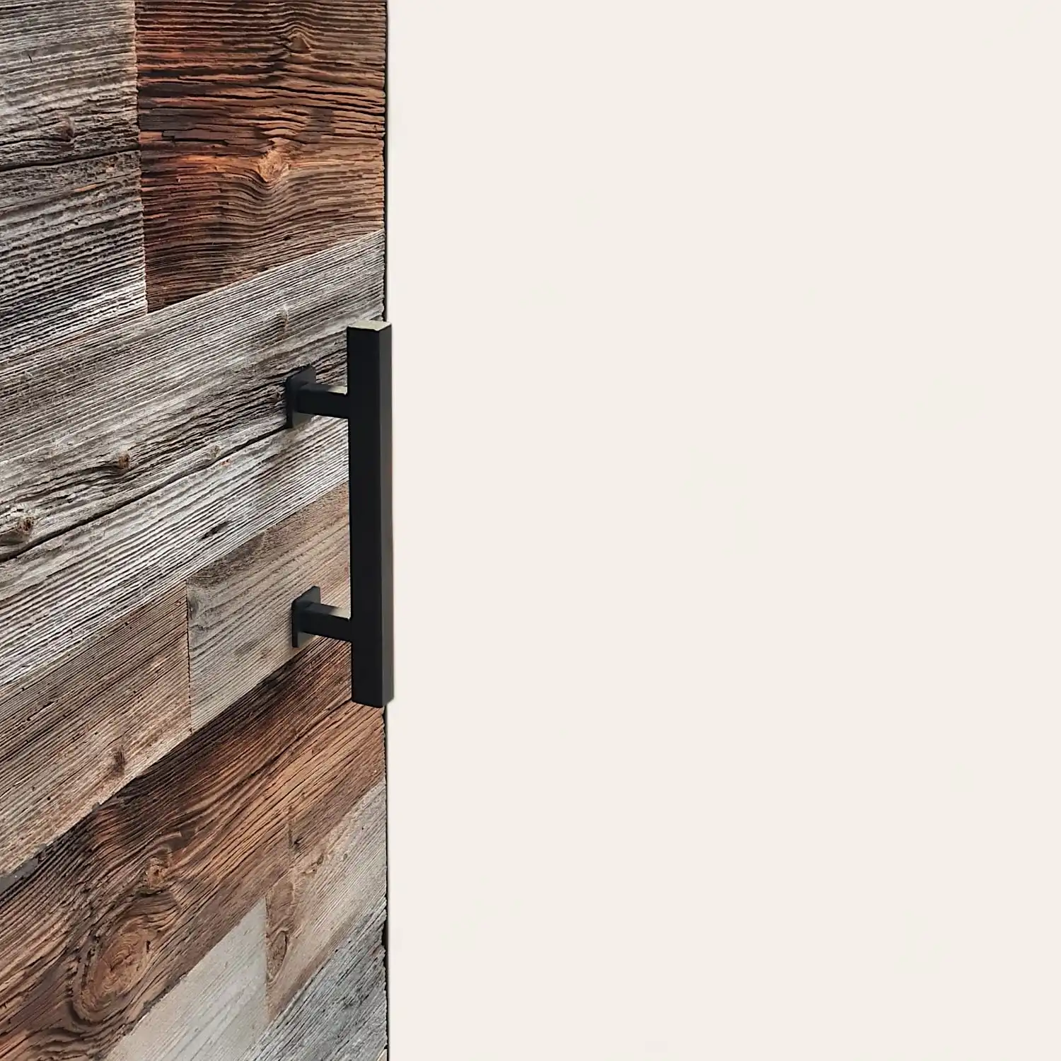  Une porte coulissante en bois vieilli avec une poignée noire. 