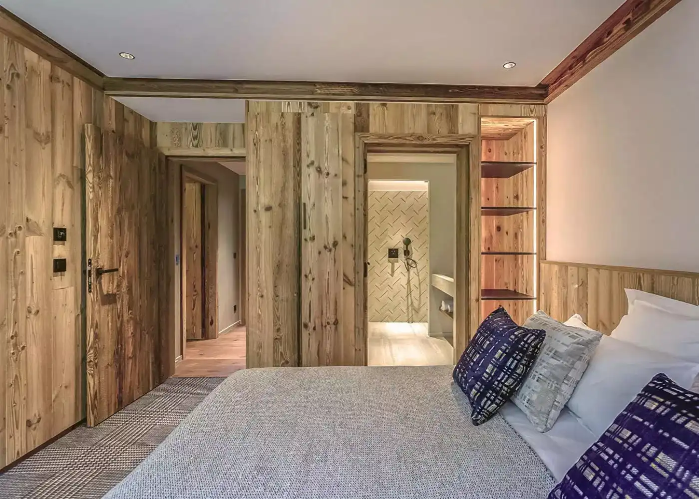 Une chambre avec des murs en bois vieilli et un lit.
