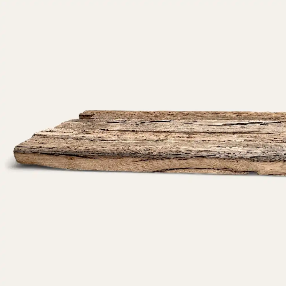  Une planche rustique en bois de vieux chêne avec une texture rugueuse et patinée, positionnée horizontalement sur un fond blanc uni. 